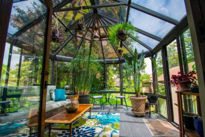 Modern four-season sunroom in Southern Wisconsin featuring high-performance glass, comfortable furniture, and a view of a spring day.