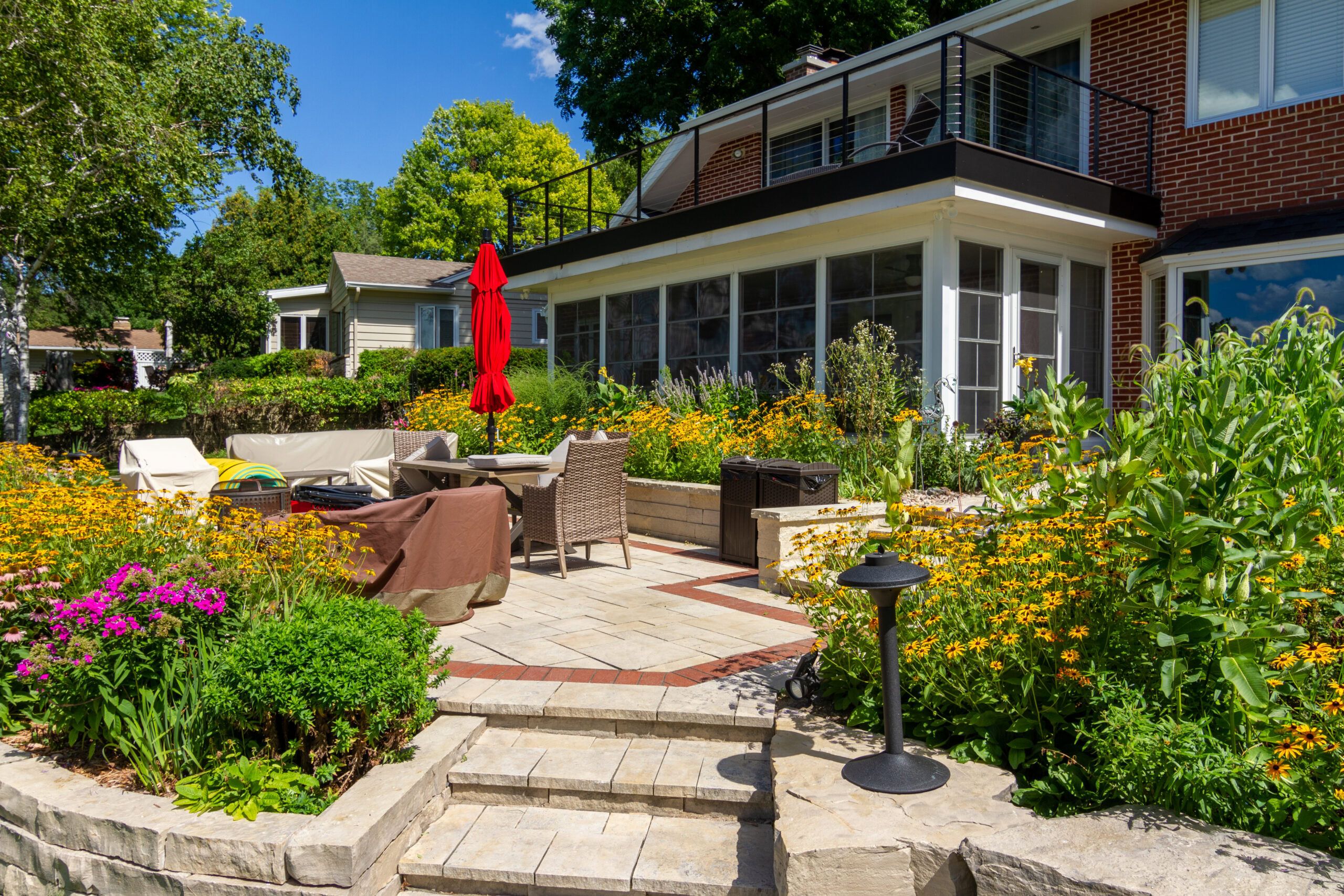 Beautiful custom 3 season room addition with large glass windows overlooking a landscaped backyard patio in Madison, Wisconsin.