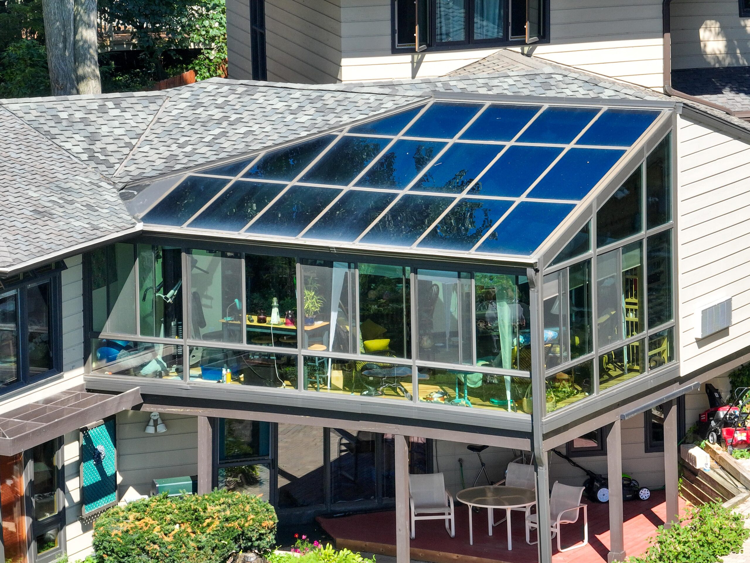 Elevated custom glass solarium sunroom enclosure with glass roof panels built on a home in Madison, WI.